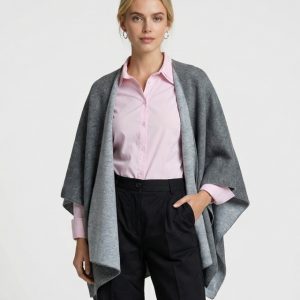 Junge Dame trägt elegantes Cape in hellgrau