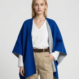 Junge Dame trägt ein royalblaues gestricktes Cape