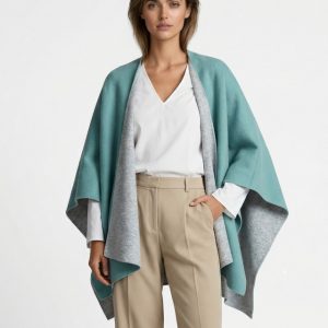 Junge Dame trägt gestrickes Wollcape in türkis