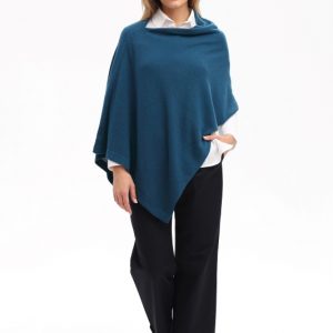 Dame trägt gestrickten Poncho in petrolgrün