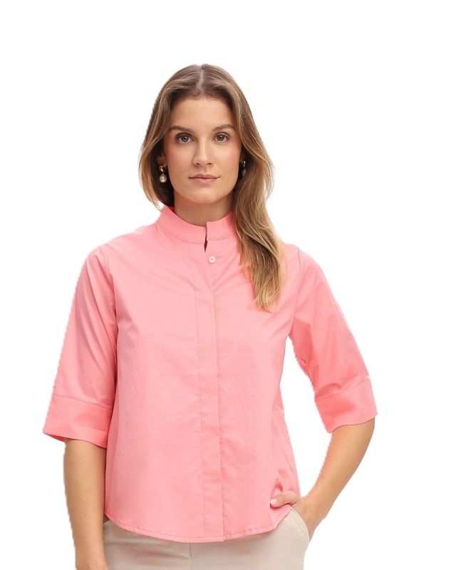 Frau trägt kurzärmelige Bluse it Stehkragne in apricot