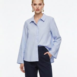 Junge Frau trägt eine Bluse in hellblau